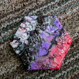 A marbled resin painting with glitter and pink cry